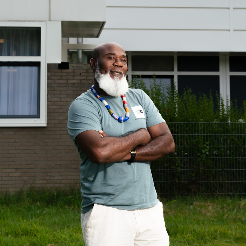 Stoere woonbegeleider kijk jou aan met zijn armen over elkaar